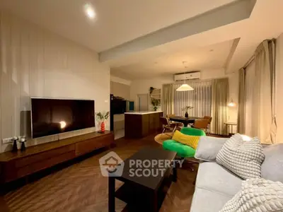 Stylish modern living room with open kitchen and cozy seating area.