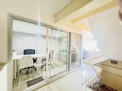 Modern office space with glass partition and sleek furniture