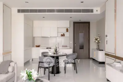 Modern open-plan living room with sleek kitchen and elegant dining area, featuring minimalist design and neutral tones.