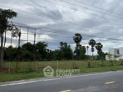 Prime land for sale with lush greenery and road access, perfect for development opportunities.