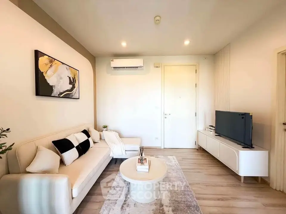 Modern living room with stylish decor and natural light, featuring a cozy sofa and sleek TV unit.