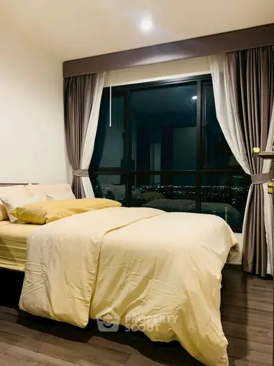 Cozy bedroom with city view and elegant curtains, perfect for relaxation.