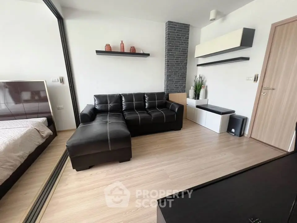 Modern living room with sleek black leather sofa and minimalist decor