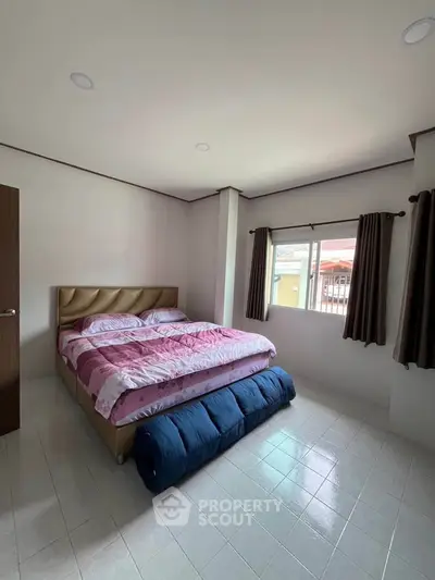 Cozy bedroom with large window and stylish bed in modern home