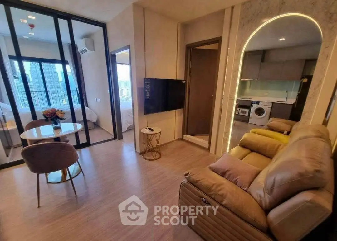 Modern living room with open kitchen and city view, featuring cozy seating and stylish decor.