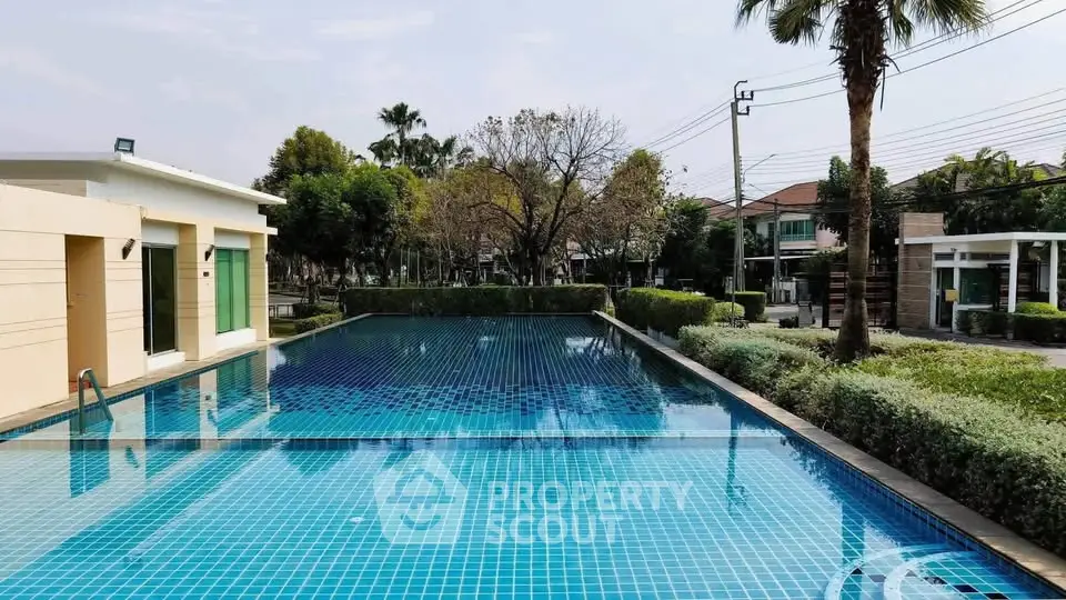Luxurious residential swimming pool with serene surroundings and lush greenery, perfect for relaxation and leisure.