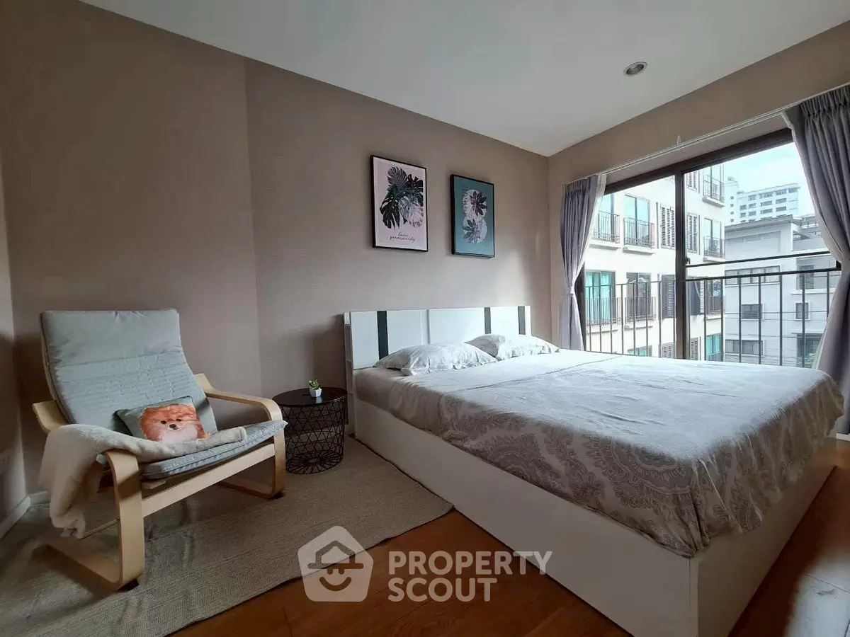 Cozy bedroom with large window and modern decor in urban apartment