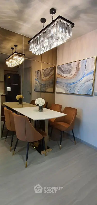 Elegant dining area with modern chandelier and abstract art, perfect for stylish gatherings.