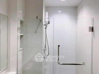 Modern bathroom with sleek glass shower enclosure and white tiles