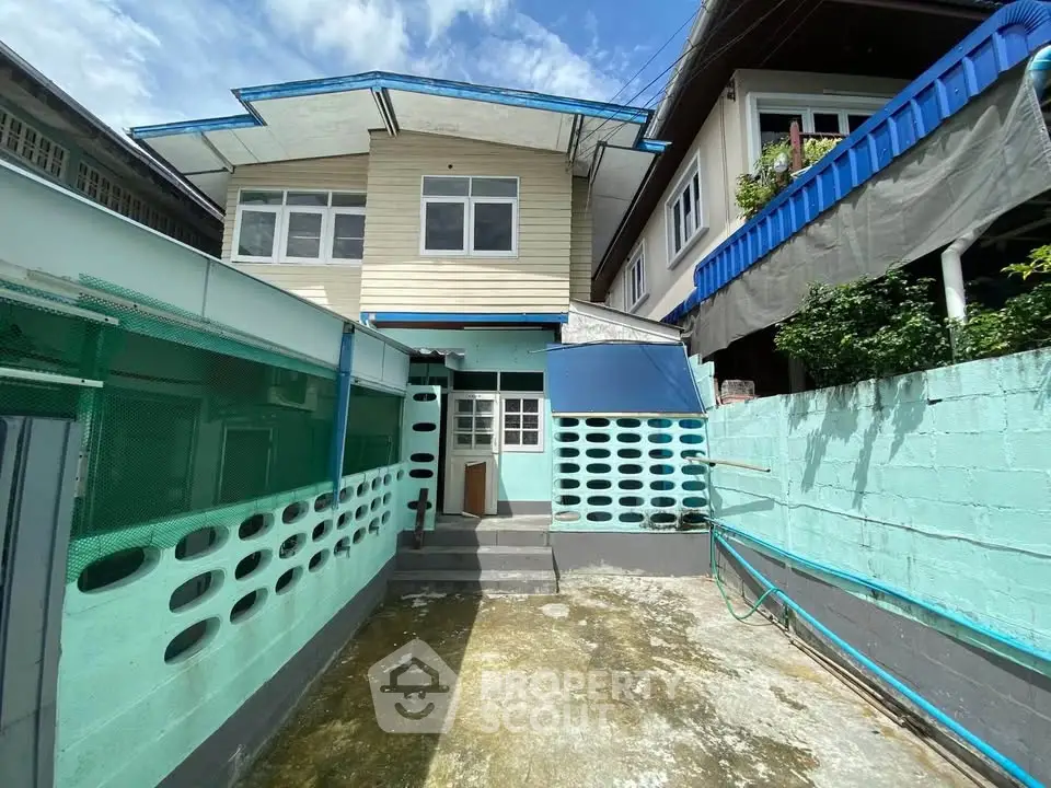 Charming two-story home with unique exterior design and spacious outdoor area, perfect for family living.