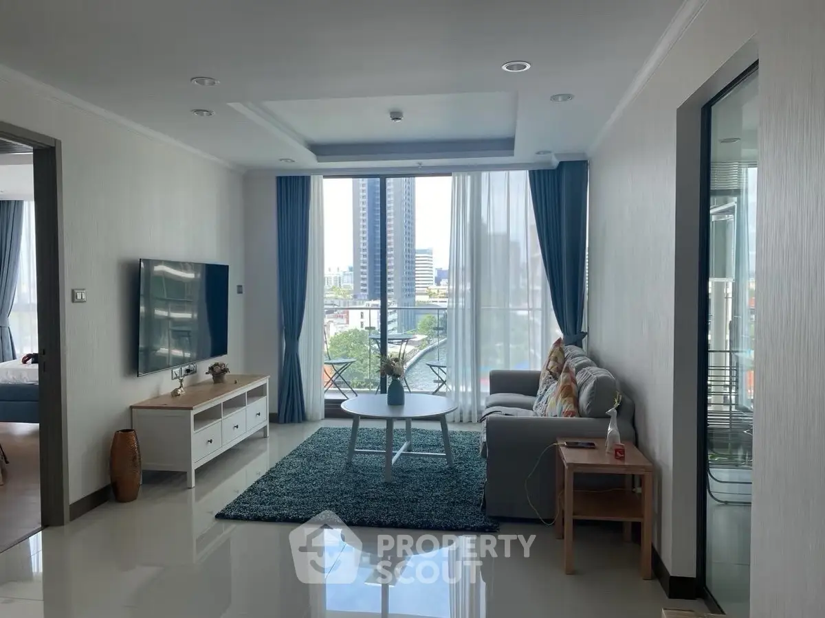 Spacious modern living room with large windows and city view, featuring stylish furniture and elegant decor.