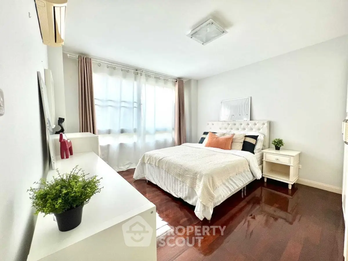 Bright and airy bedroom with elegant decor and hardwood floors