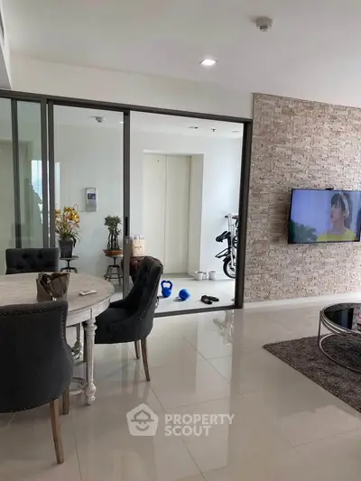 Modern living room with stylish furniture and exercise area in open layout apartment.