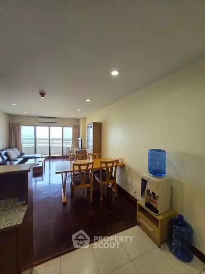 Spacious living room with dining area and balcony access in modern apartment