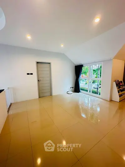 Spacious modern living room with glossy tiled floor and large window view.