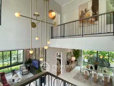 Luxurious open-plan living room with modern chandelier and mezzanine view.