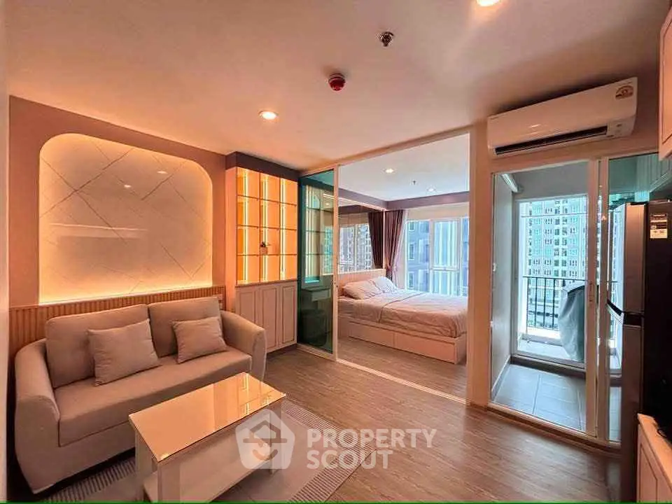 Modern open-plan living room with cozy bedroom and balcony view in stylish apartment.