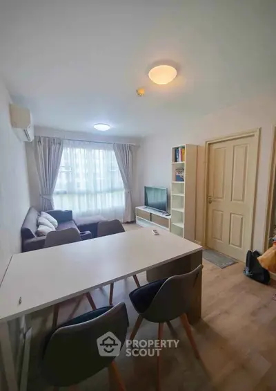 Modern living room with cozy seating and natural light in stylish apartment.