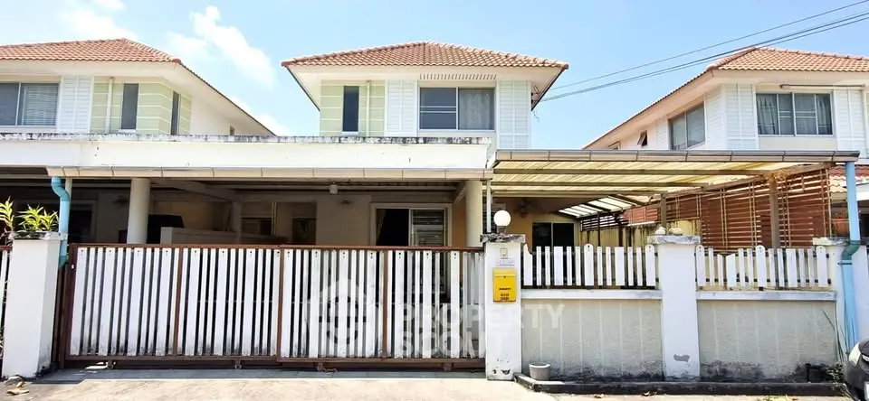 Charming suburban house with gated driveway and tiled roof, perfect for family living.