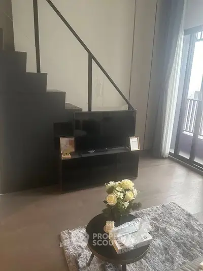 Modern living room with stylish decor and large windows offering natural light.