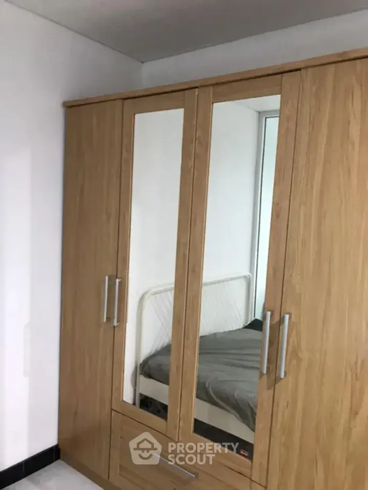 Spacious bedroom with wooden wardrobe and cozy bed setup