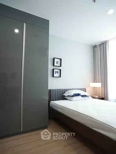 Modern bedroom with sleek wardrobe and cozy bed in bright apartment