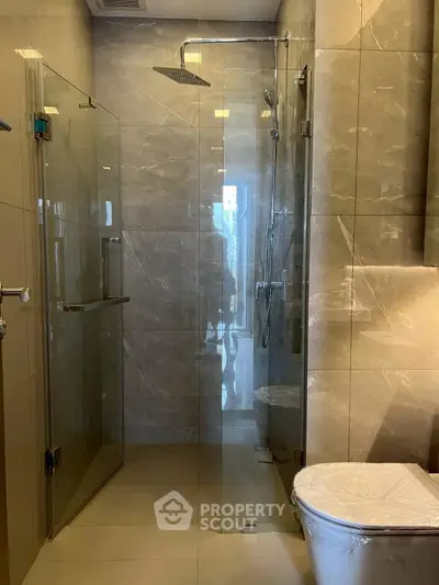 Luxurious modern bathroom with glass shower and elegant marble tiles