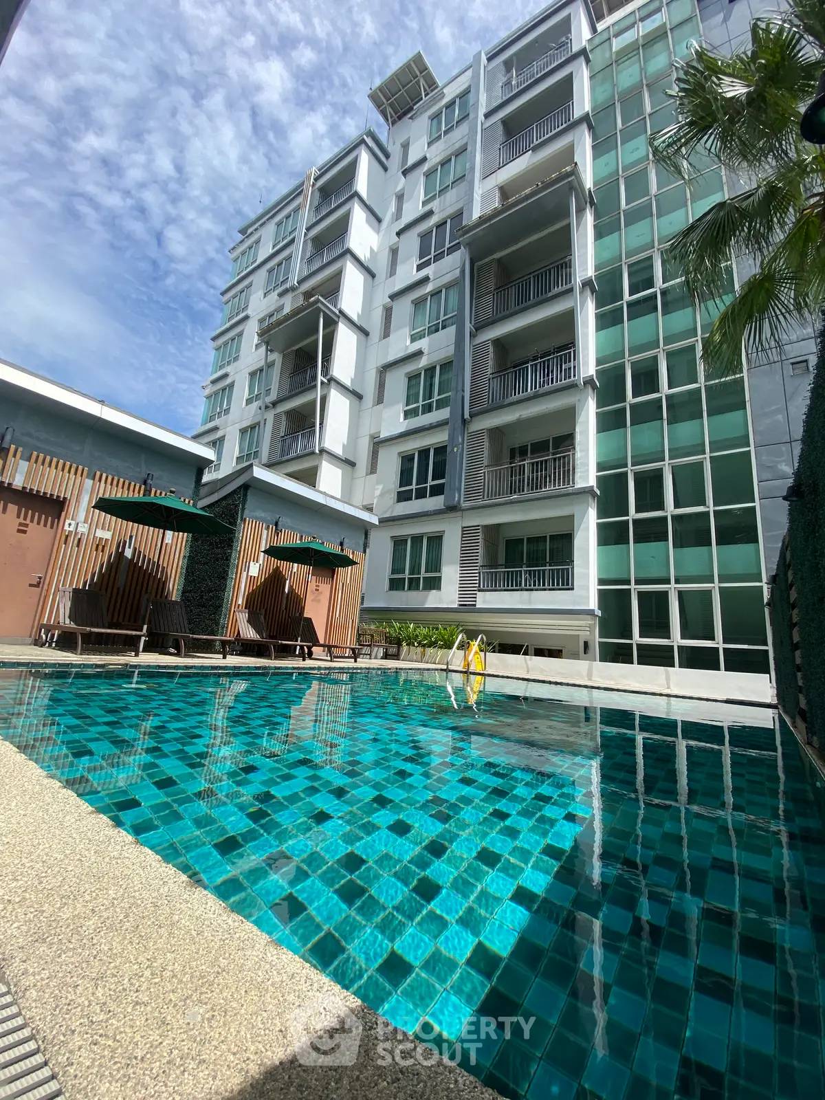 Luxurious condominium with a stunning pool and modern architecture, perfect for urban living.