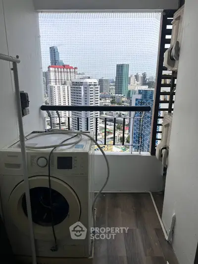 High-rise apartment balcony with washing machine and stunning city view.