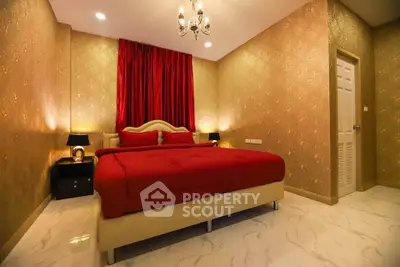 Luxurious bedroom with elegant decor and plush red bedding in a stylish real estate property.