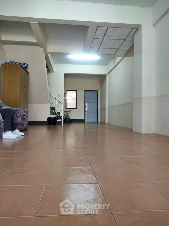 Spacious interior with tiled flooring and minimal furniture, ideal for customization.