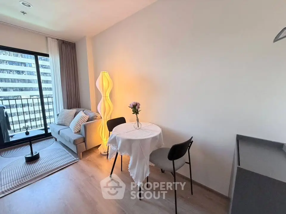 Modern living room with cozy seating and dining area, featuring a stylish floor lamp and city view.