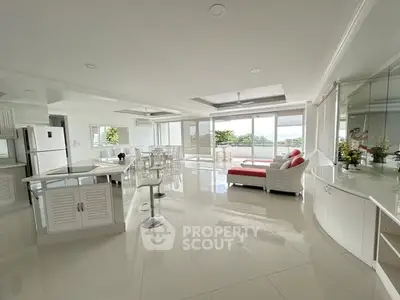 Spacious open-plan living room with modern decor and large windows offering stunning views.