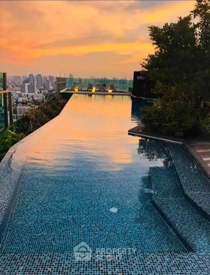 Stunning rooftop infinity pool with breathtaking city skyline view at sunset.
