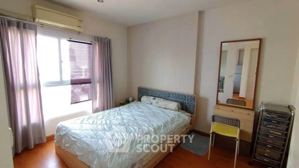 Cozy bedroom with natural light, featuring a comfortable bed, air conditioning, and stylish decor.