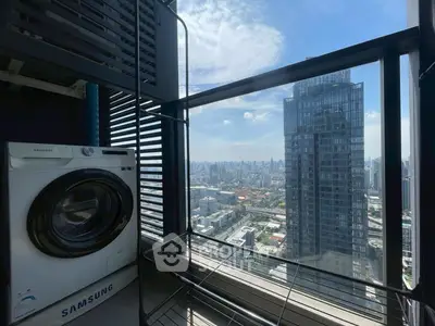 High-rise apartment with washer and stunning city view from balcony.