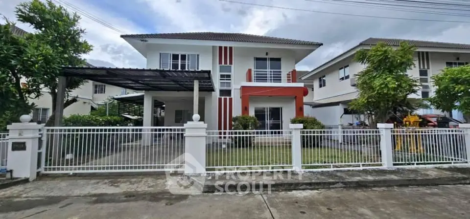 Modern two-story house with a spacious front yard and gated entrance in a suburban neighborhood.