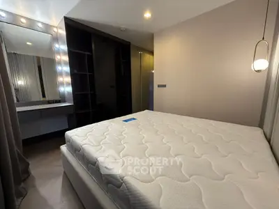 Modern bedroom with illuminated vanity and stylish pendant lighting.