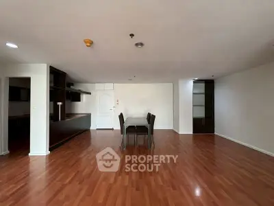 Spacious open-plan living area with wooden flooring and modern furnishings.