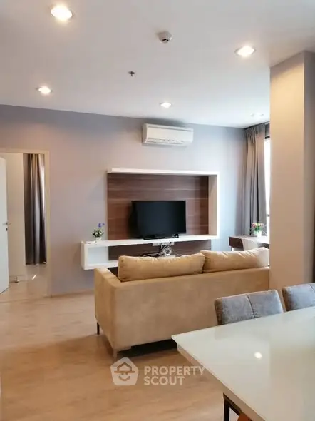 Modern living room with stylish furniture and wall-mounted TV, perfect for relaxation.