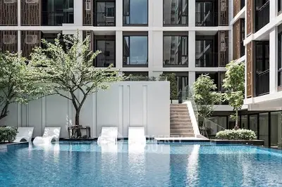 Luxurious modern apartment complex with stunning pool and lush greenery.