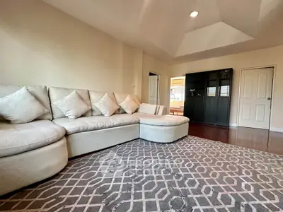 Spacious living room with modern sectional sofa and elegant geometric rug.