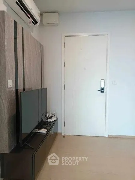 Modern living room with sleek TV setup and air conditioning unit.