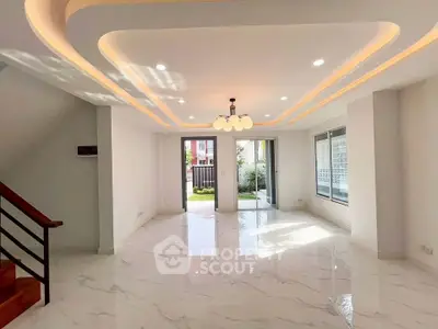 Spacious modern living room with elegant lighting and large windows, perfect for natural light.