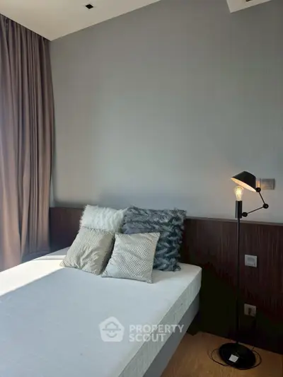 Modern bedroom with stylish decor and cozy lighting, featuring a comfortable bed and elegant curtains.
