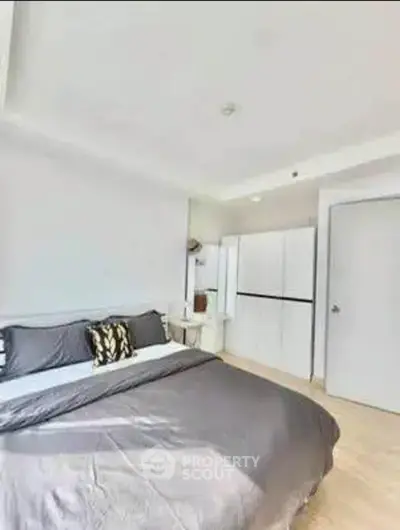 Spacious modern bedroom with stylish decor and ample natural light