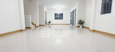 Spacious modern living room with glossy tiled floors and large windows.