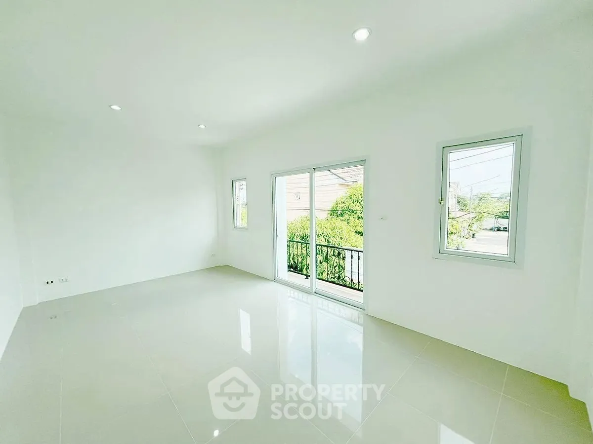 Spacious bright room with large windows and sliding doors opening to a balcony, perfect for natural light lovers.