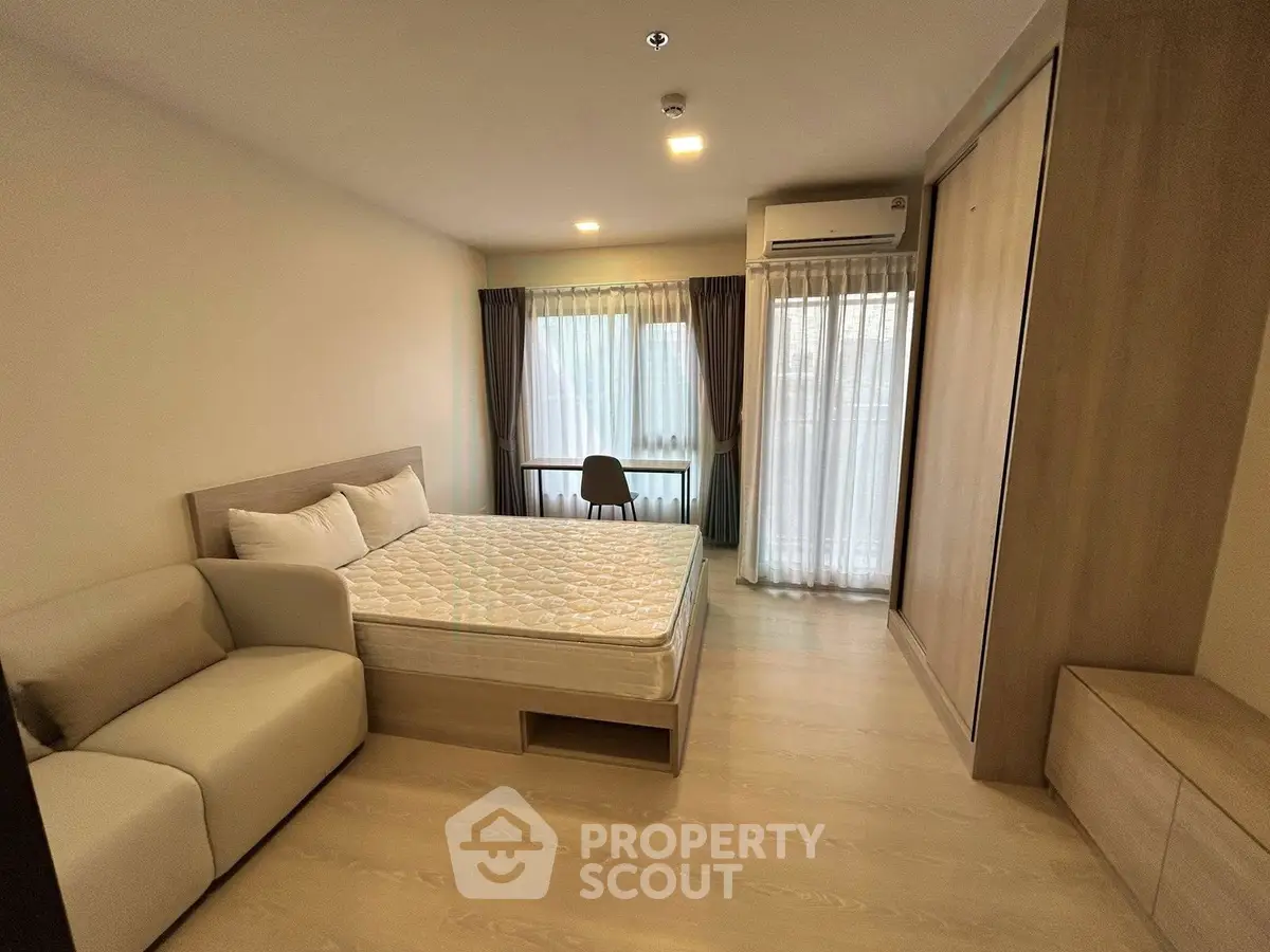 Spacious bedroom with modern furnishings and natural light in a stylish apartment.