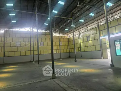 Spacious industrial warehouse with high ceilings and ample natural light.